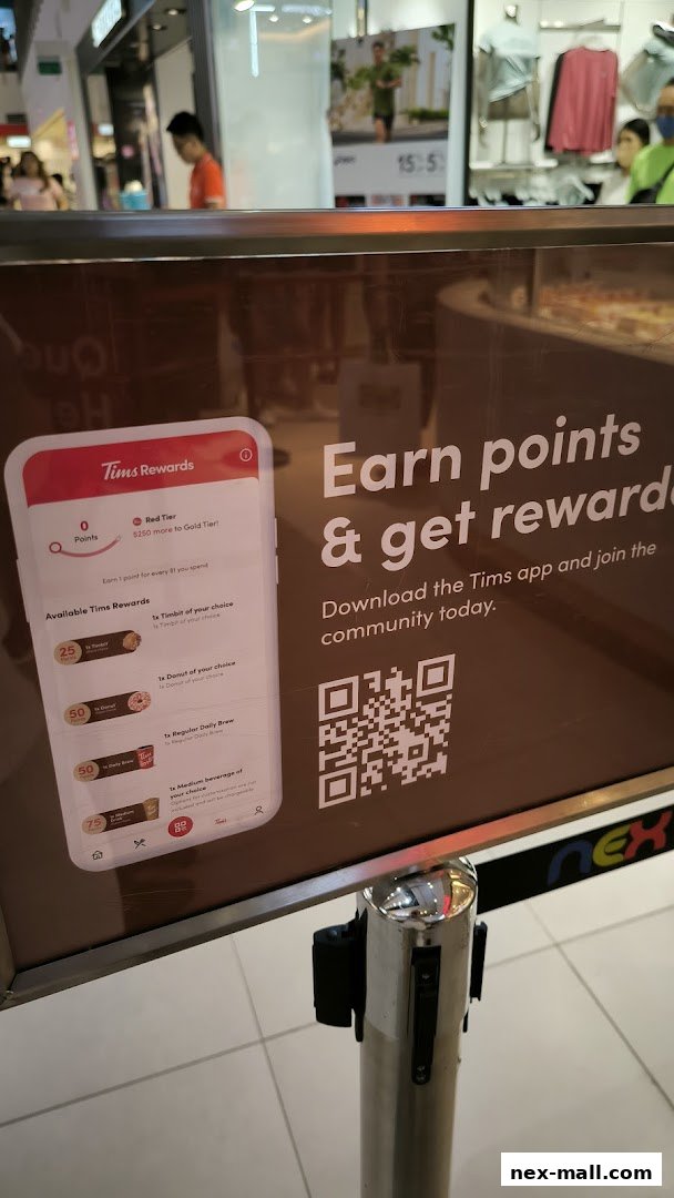 A sign promoting Tim Hortons rewards and app download with a QR code.