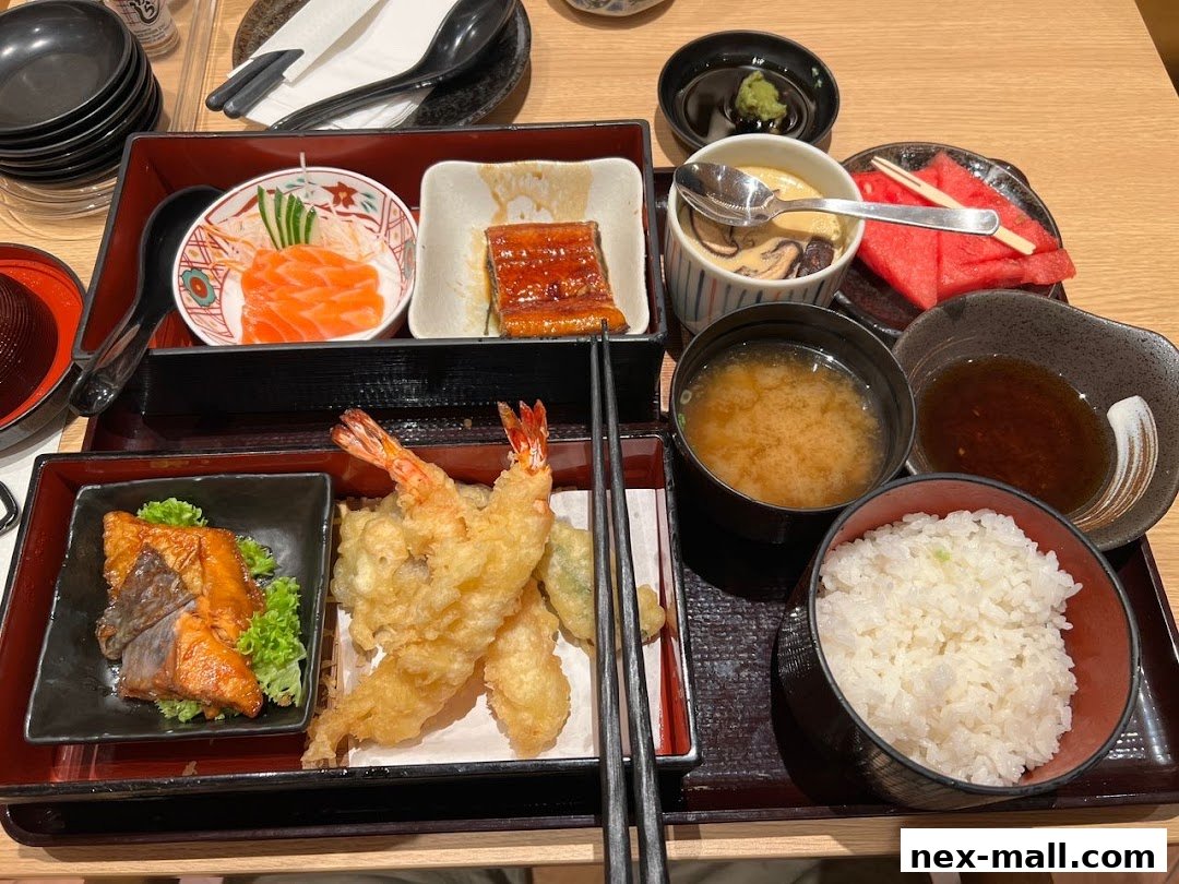 A delicious Japanese bento box with salmon sashimi, grilled eel, tempura, and miso soup.