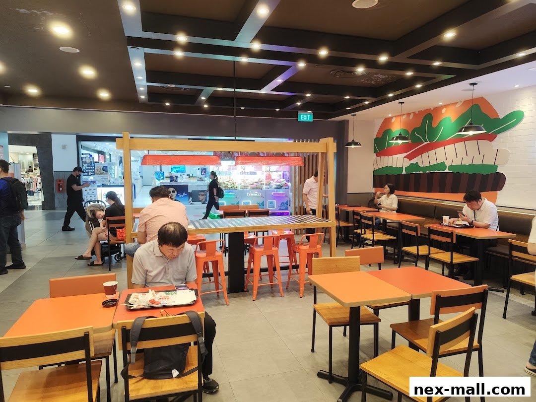 Interior of a Burger King restaurant with customers dining and a large burger mural on the wall.