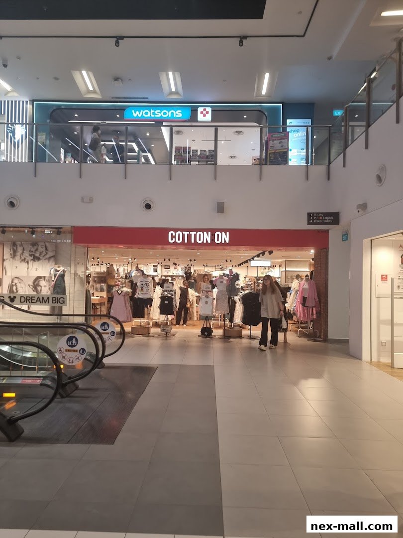 The Cotton On store entrance with mannequins displaying clothing and shoppers inside.