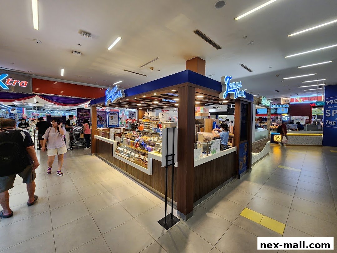 A Famous Amos cookie store kiosk in a mall with customers browsing.