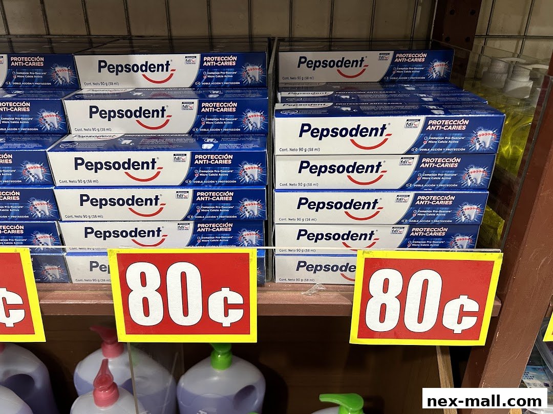 Shelves stocked with Pepsodent toothpaste boxes, some with price tags.