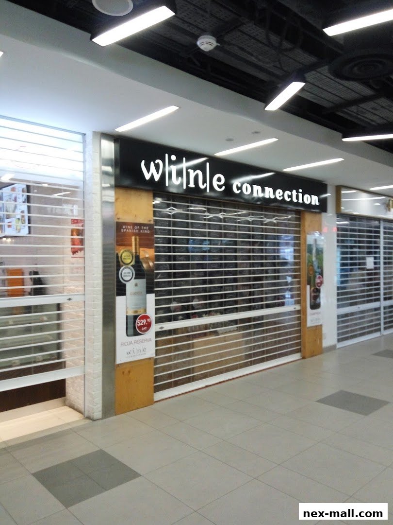 The Wine Connection NEX shop front with its signage and a promotional display for wine.