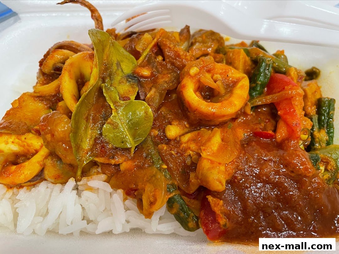 A close-up shot of a delicious squid curry served over fluffy white rice.