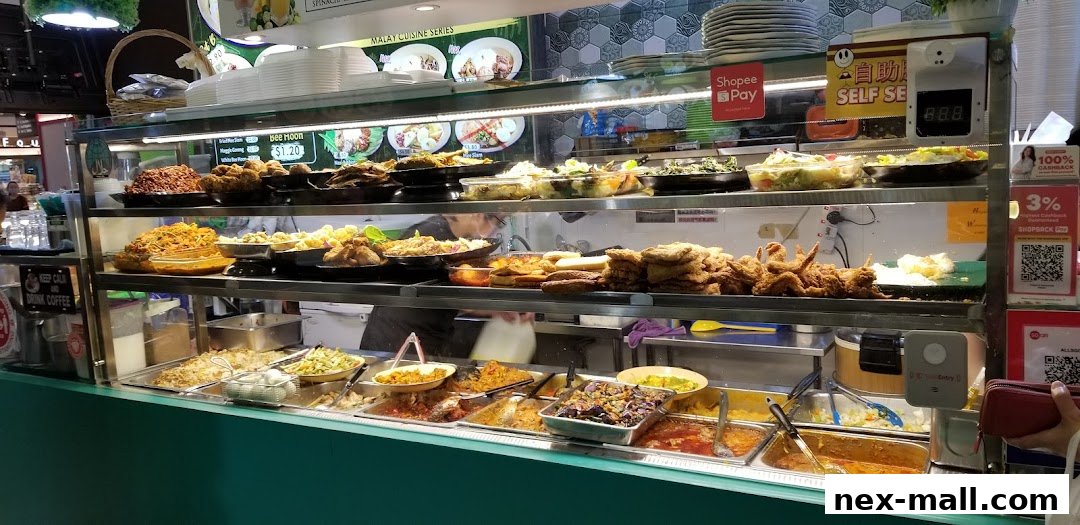 A display of various Malay cuisine dishes in a food stall, with prices and payment options visible.