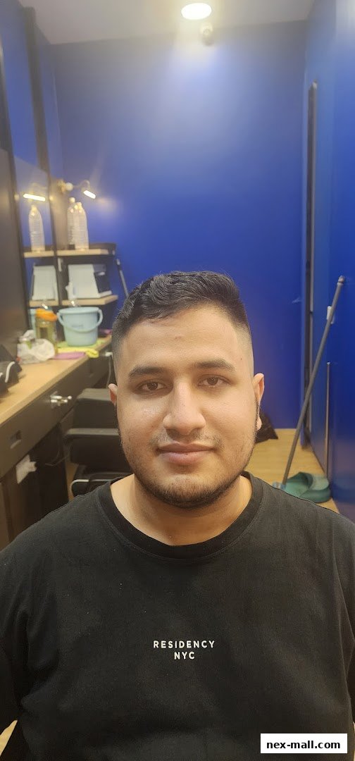 A man with a fresh haircut and beard at Clippers Barber NEX.