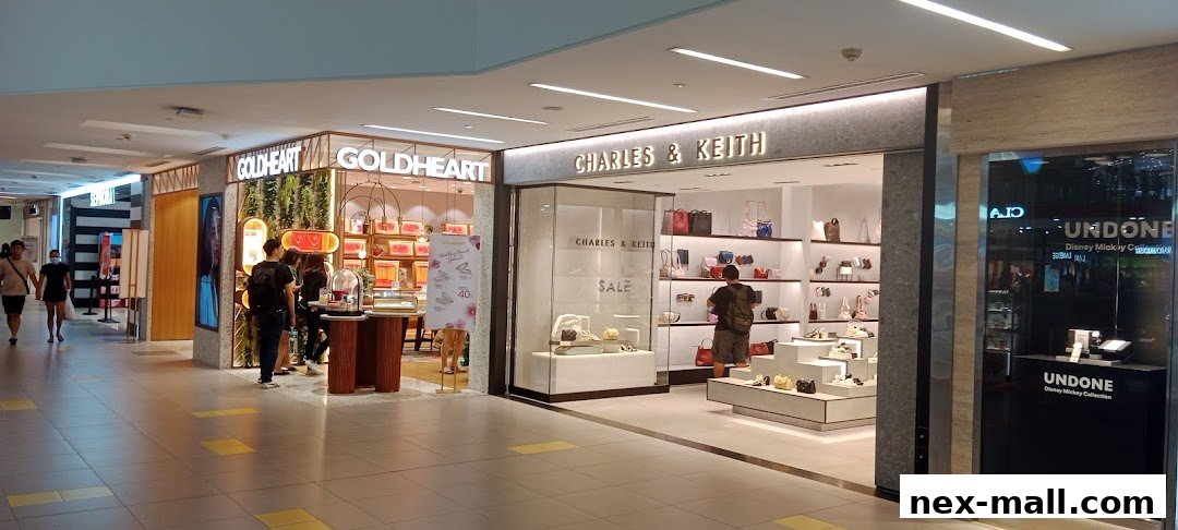 The exterior of Charles & Keith and Goldheart shops in a mall, showcasing handbags and jewelry.