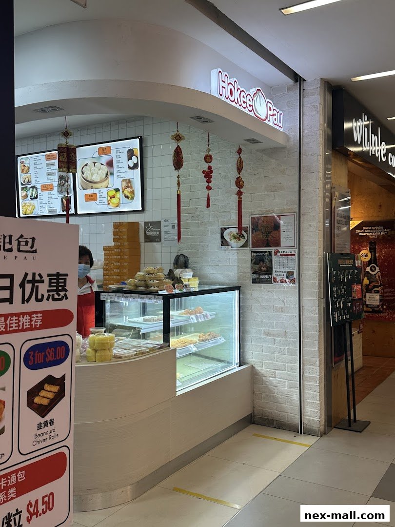 The Ho Kee Pau shop front with a display of steamed buns and a menu board.
