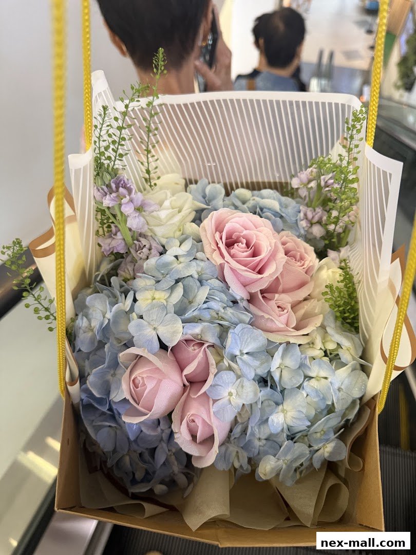 A beautiful bouquet of pink roses and blue hydrangeas in a gift box.