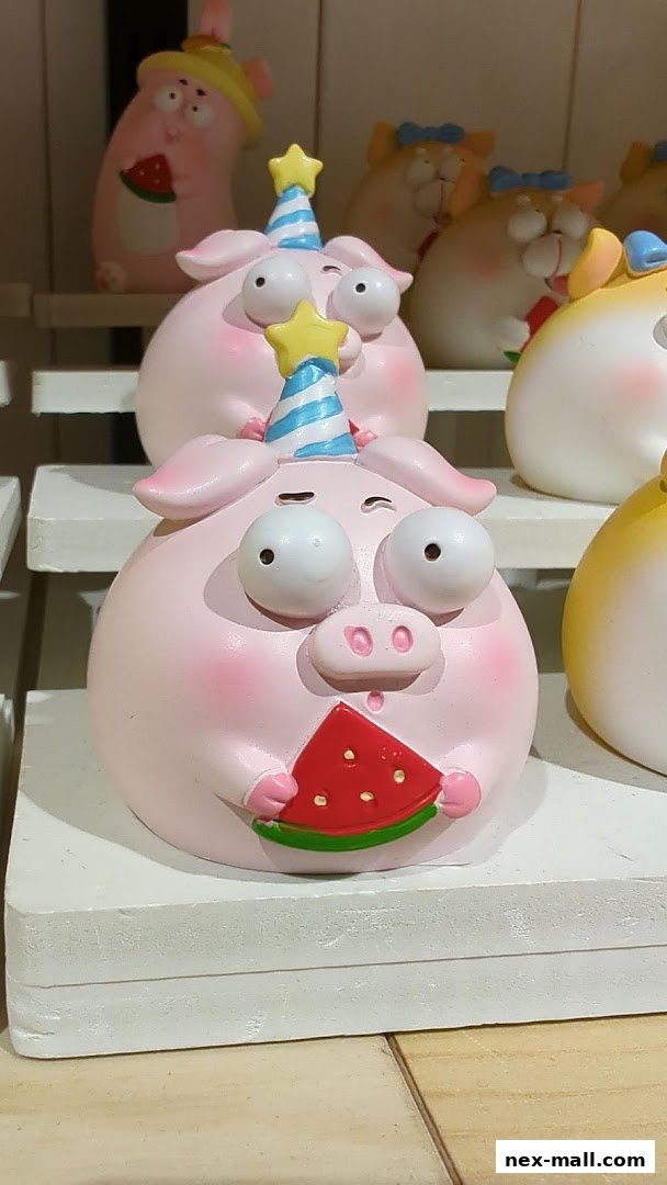 Cute pink pig figurines wearing party hats and holding watermelon slices.