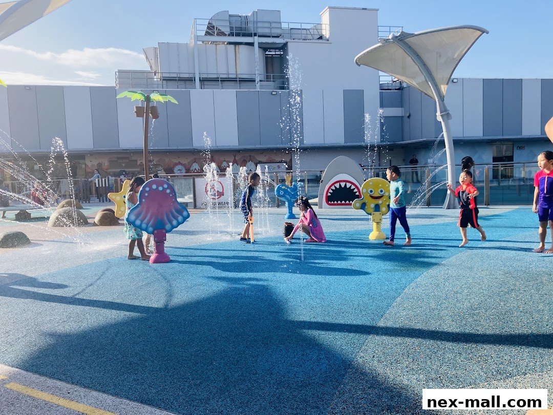 Children playing and splashing in a colorful outdoor water play area with various water features.