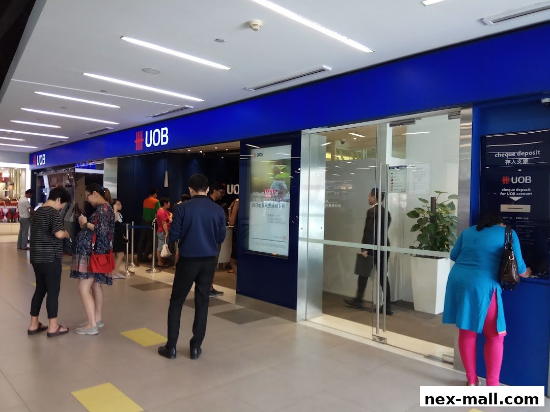 People queuing at the UOB bank branch entrance with a cheque deposit machine.