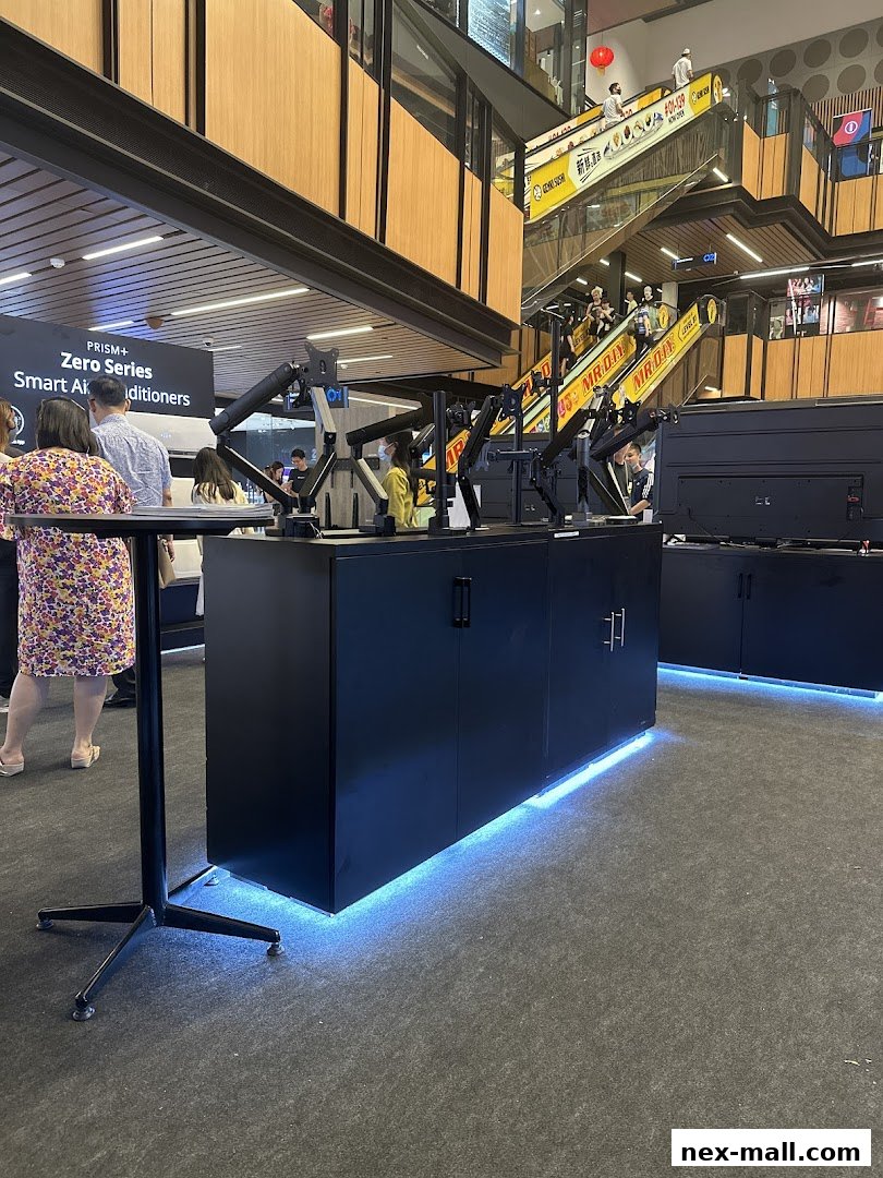 A retail display featuring monitor arms and screens with people browsing in a mall.