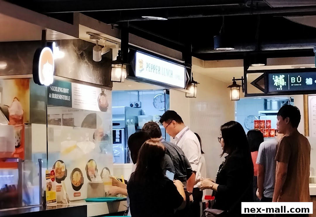 People queuing at a food stall with a sign for Pepper Lunch Express.