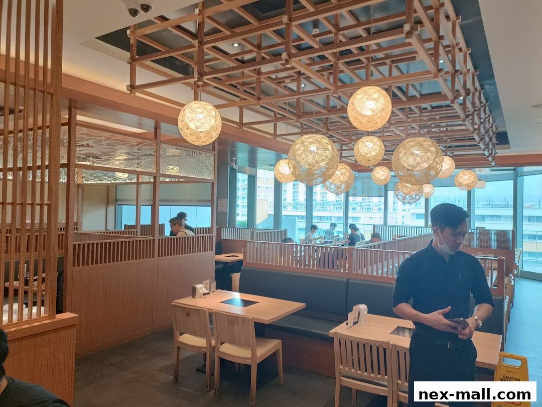 Interior of a Shabu Sai restaurant with wooden decor and hanging lamps.