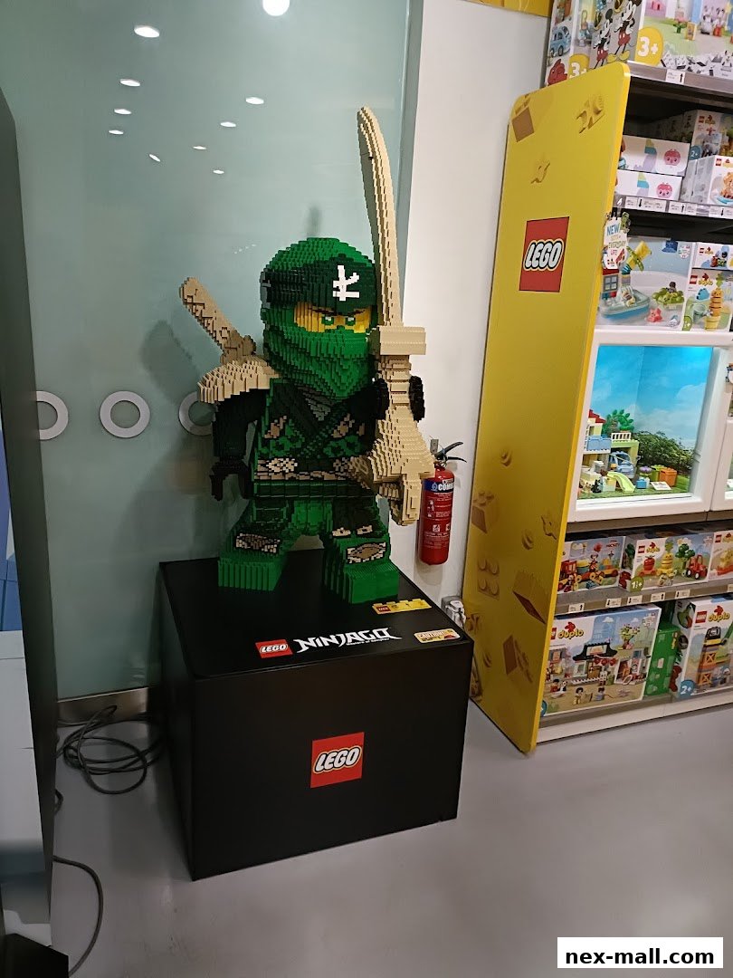 A large LEGO Ninjago character display with shelves of LEGO sets in the background.