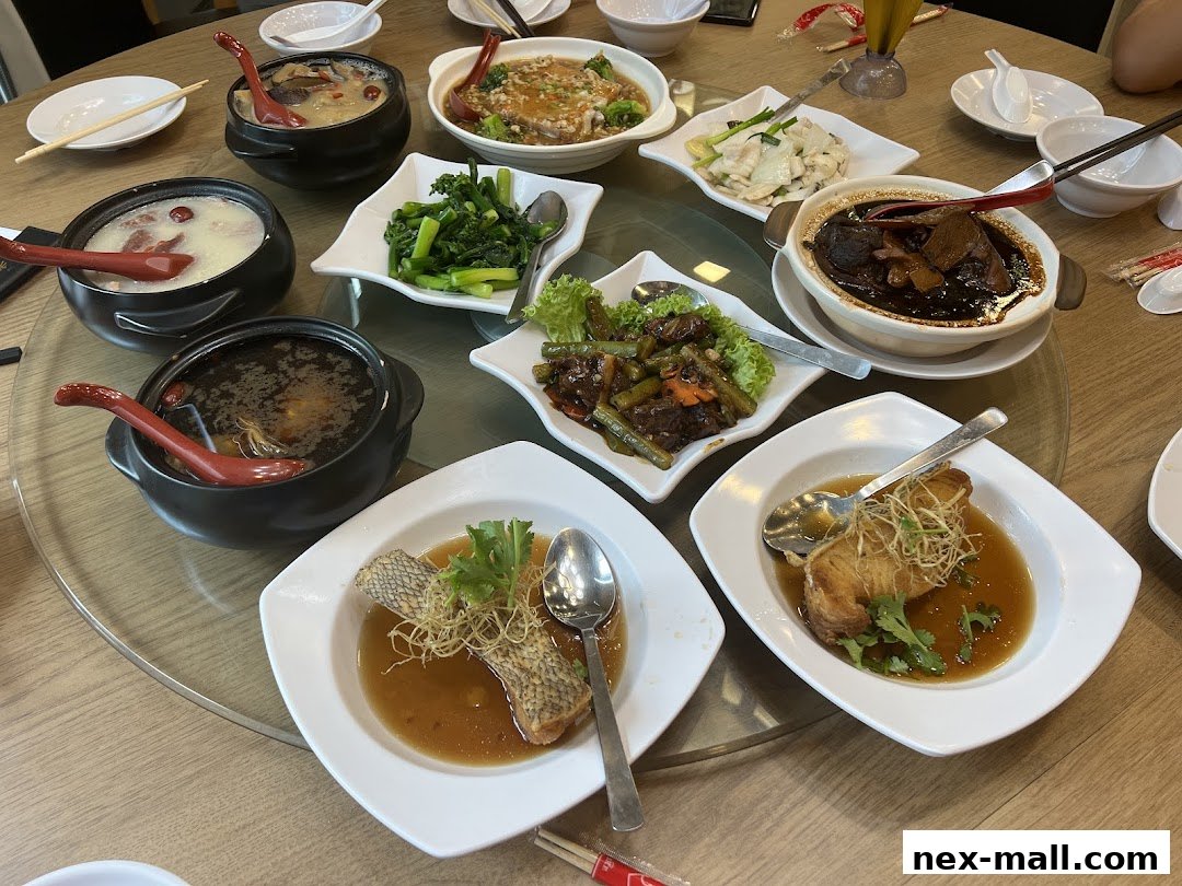 A table laden with various Chinese dishes, including soups, vegetables, and fish.