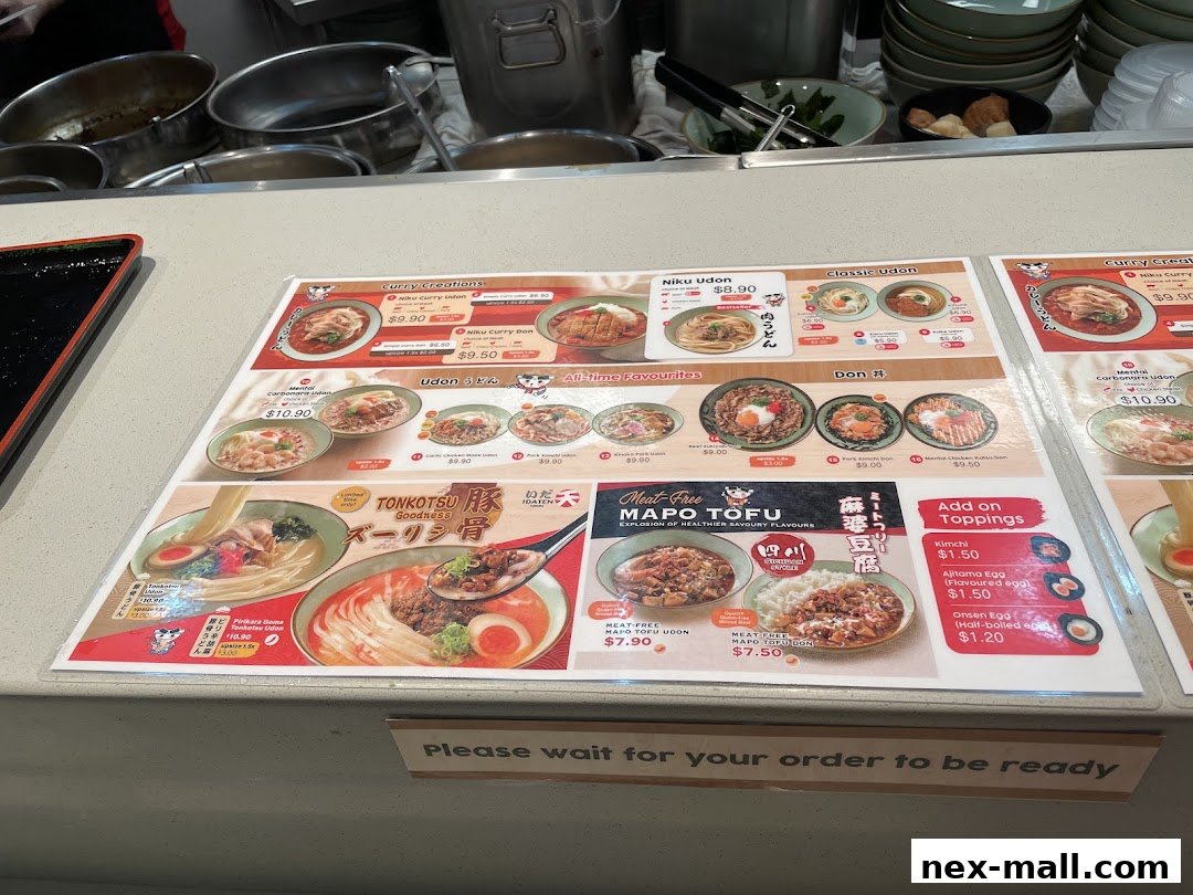 A menu display for Idaten Udon featuring various udon dishes and toppings.