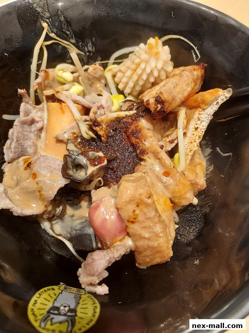 A close-up of a bowl filled with Mala Tang, featuring various ingredients like meat, seafood, and vegetables.
