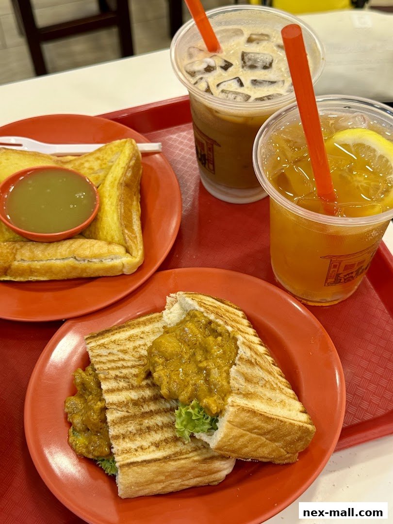 A tray of Ya Kun Kaya Toast food, featuring kaya toast, curry toast, and iced drinks.