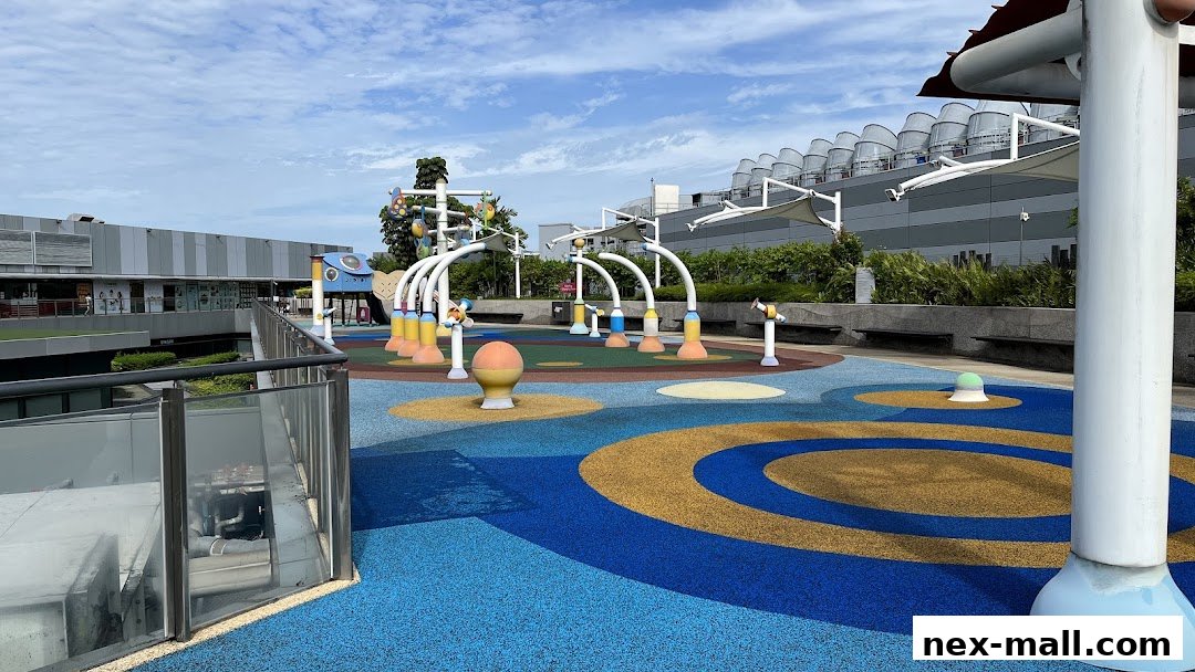 A colorful outdoor playground with water features and seating areas.