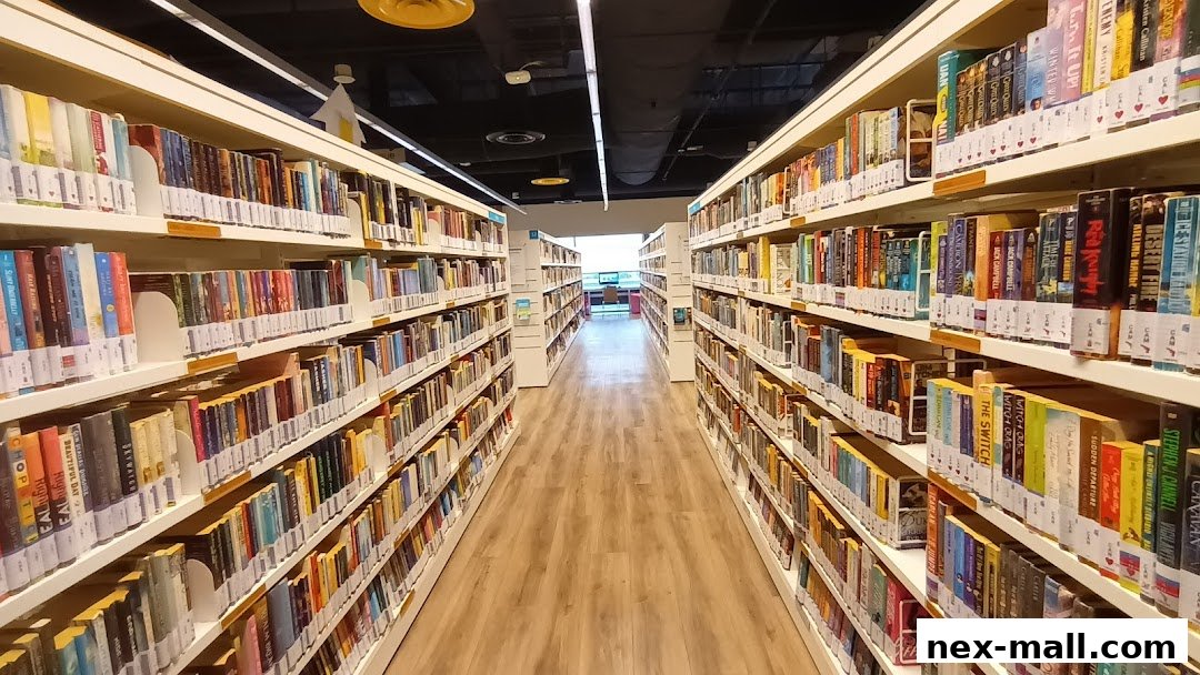 A long aisle of bookshelves filled with various books in a library.
