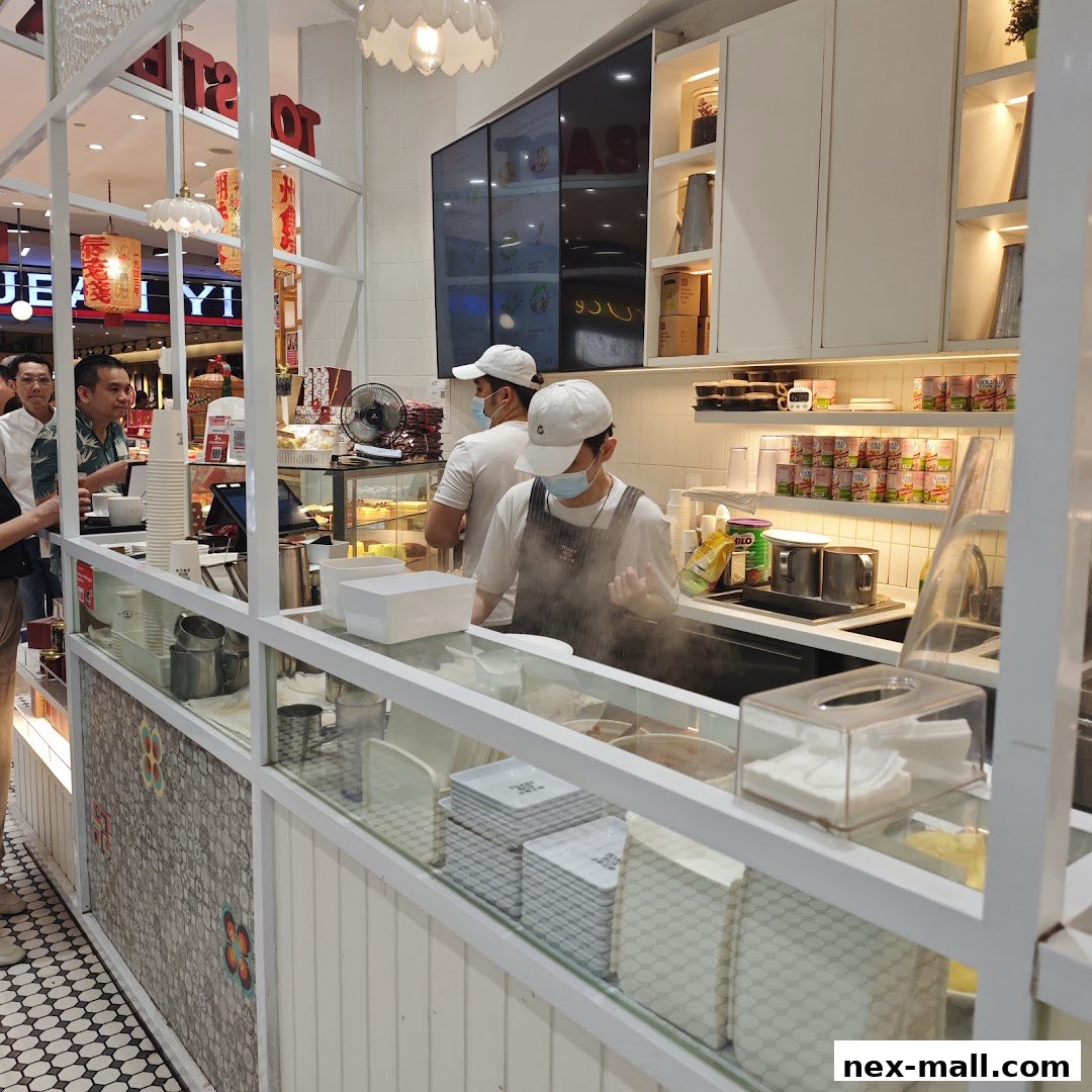 Staff preparing food behind the counter at Toast Box NEX.