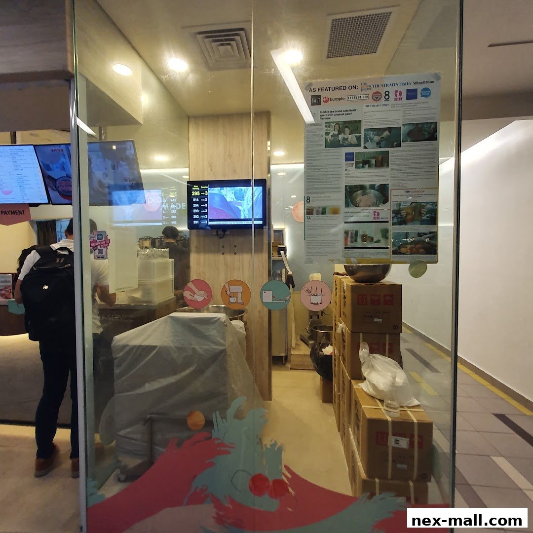 View of the PlayMade shop interior with a display screen, boxes, and a person inside.