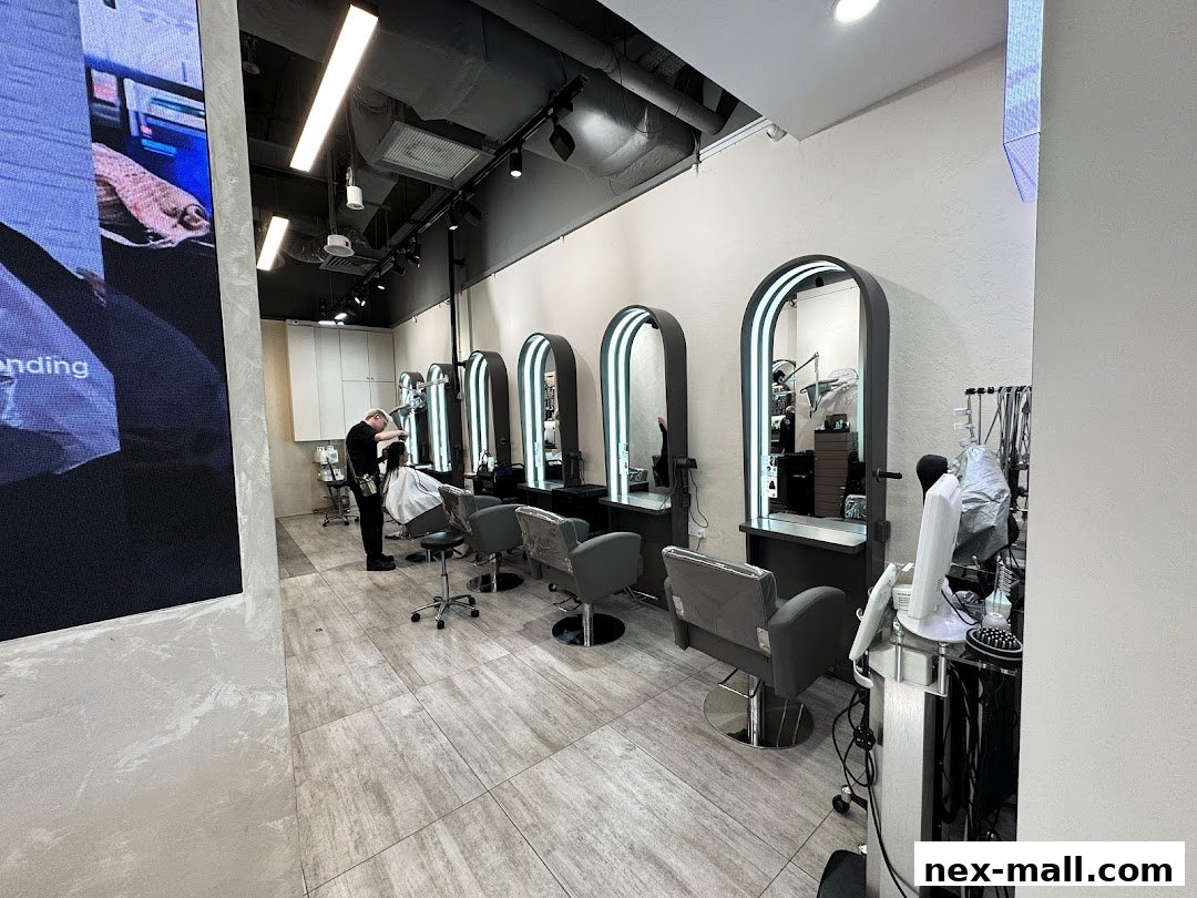 A hair stylist is cutting a client's hair in a modern salon with multiple styling stations.