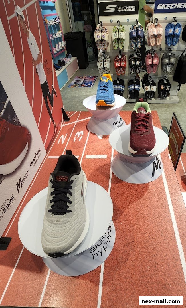 Skechers store display featuring running shoes and sandals on a track-themed floor.