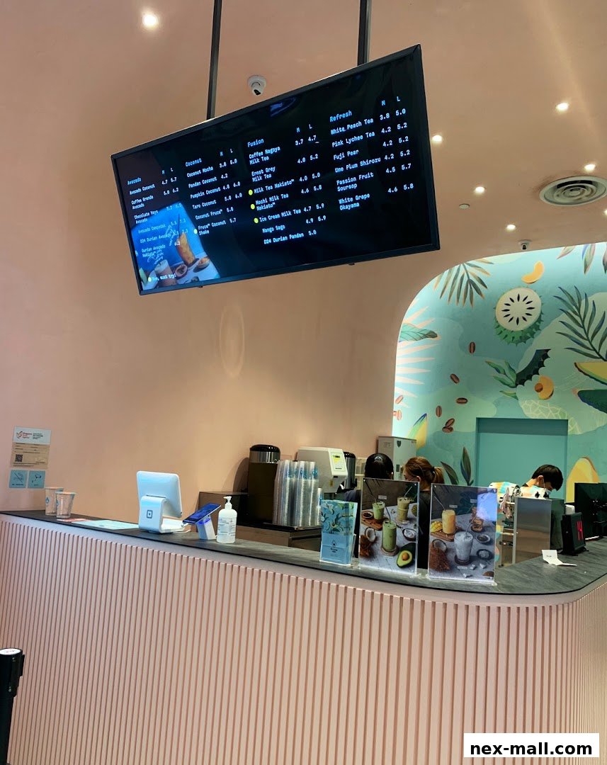 A digital menu board displaying various drinks and their prices at Fruce NEX.