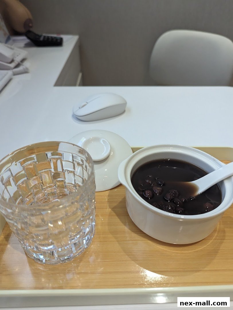 A bowl of black bean soup with a glass of water on a tray.