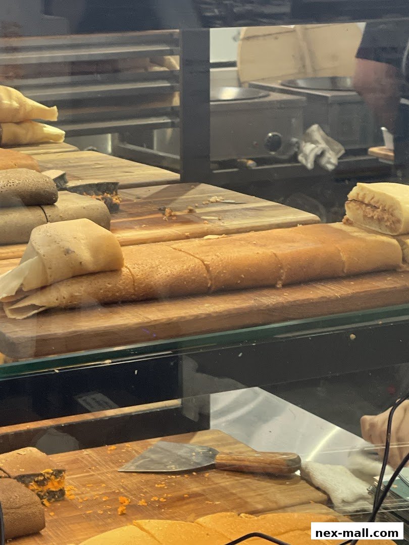 Close-up of freshly made pancakes and sweet treats displayed on wooden boards.