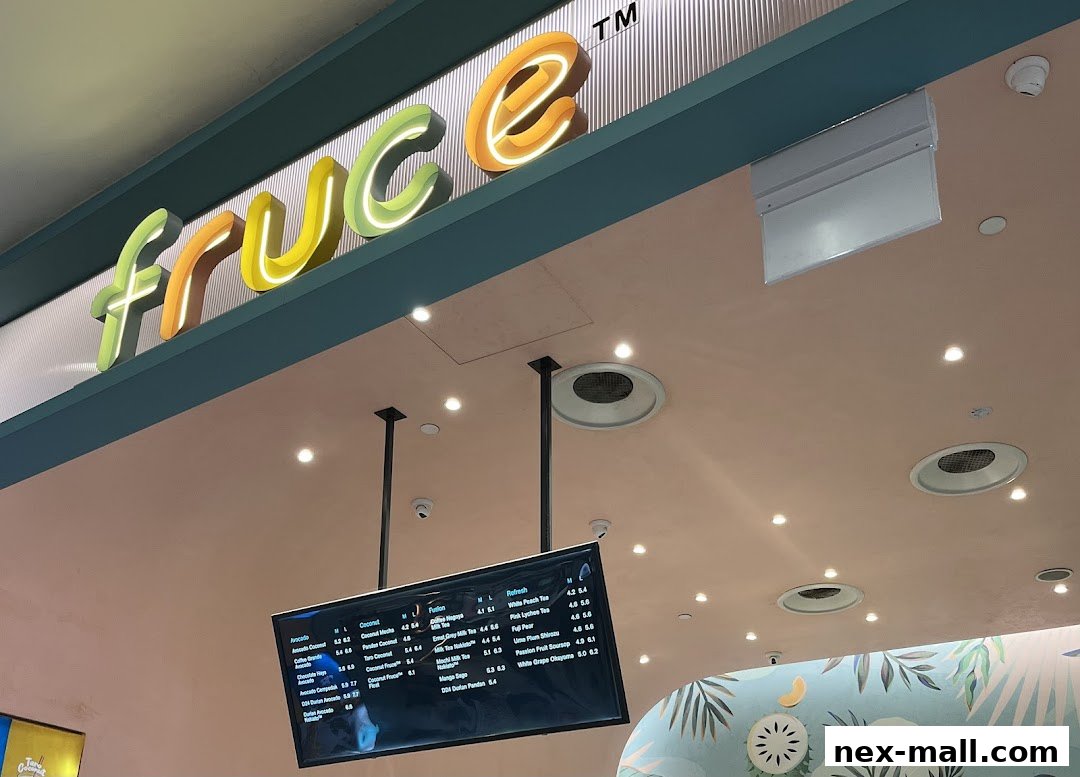 A brightly lit shop interior with a neon sign and a digital menu board displaying drinks.