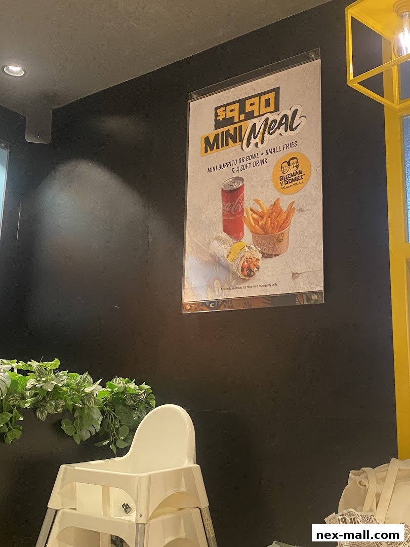 A poster advertising a $9.90 mini meal from Guzman y Gomez is displayed on a dark wall.