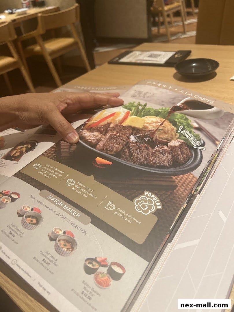 A person's hand is shown pointing at a menu featuring a steak dish and various set meals.