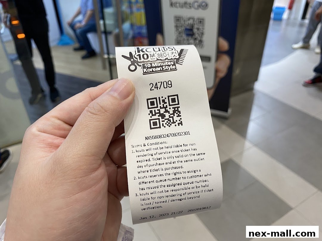 A hand holds a queue ticket from kcuts, a Korean hair salon.