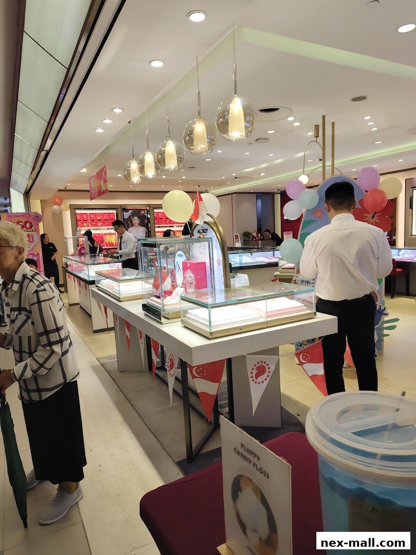 Interior view of a jewelry store with display cases, customers, and festive decorations.