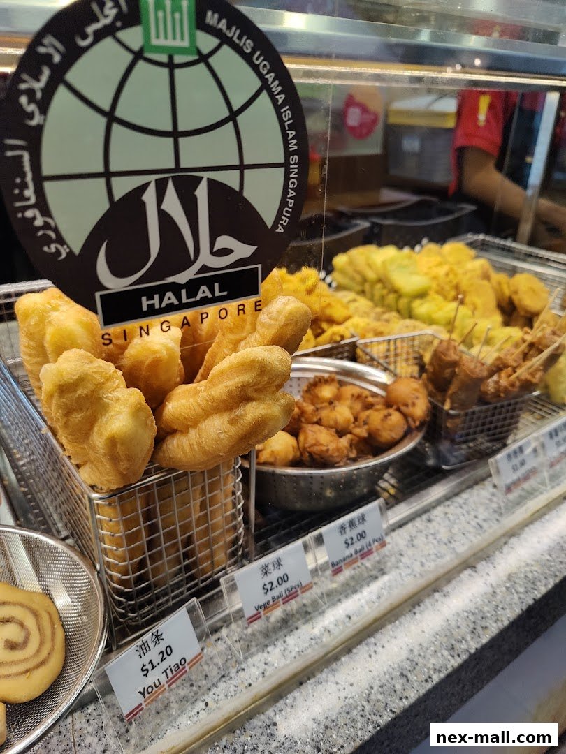 A display of various fried snacks, including You Tiao, Vege Balls, and Banana Balls, with Halal certification.