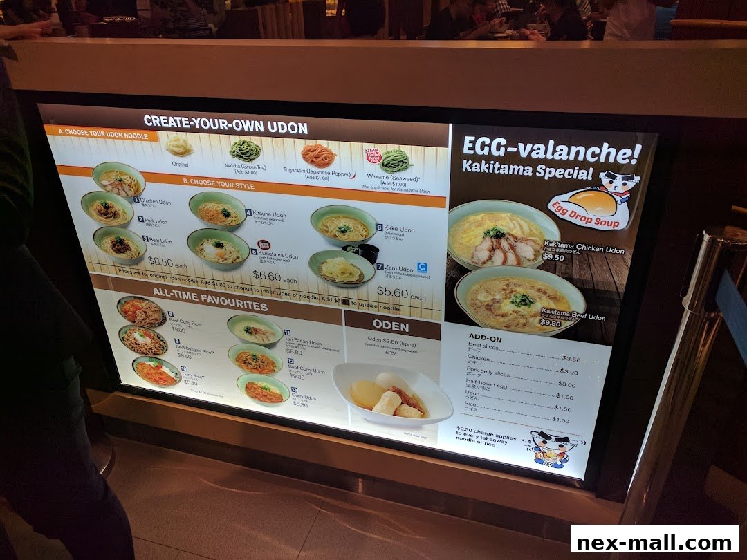 A menu board displaying various udon noodle dishes and add-on options.