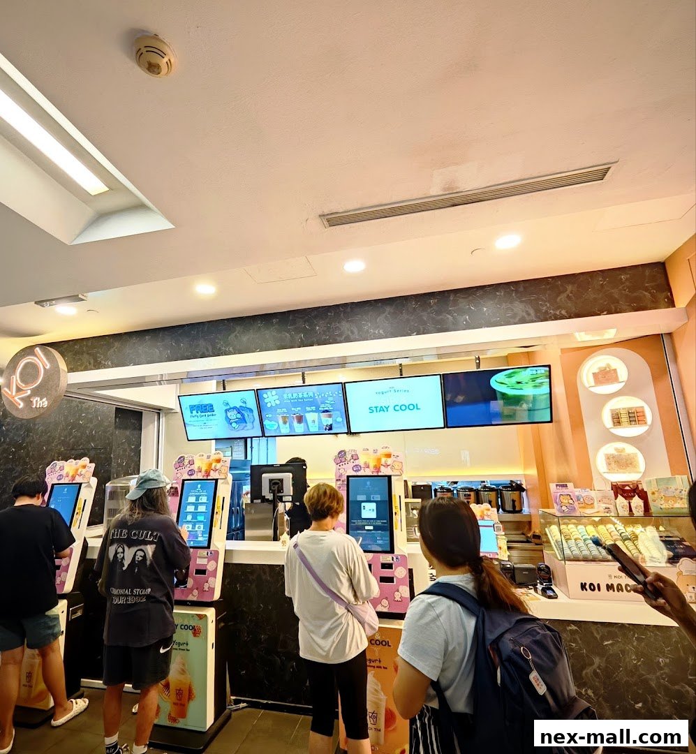 Customers ordering at self-service kiosks at KOI Thé NEX.