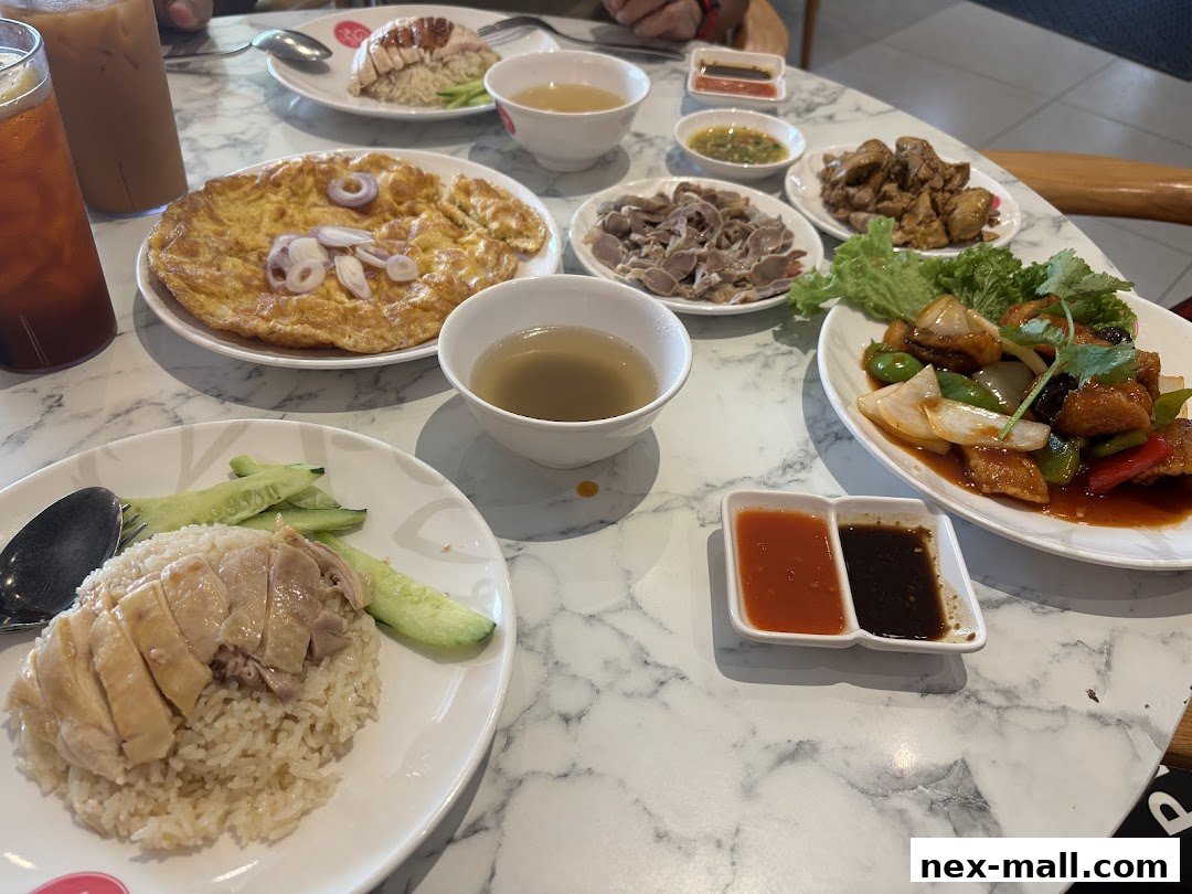 A table filled with various dishes, including chicken rice, omelet, and stir-fried chicken.