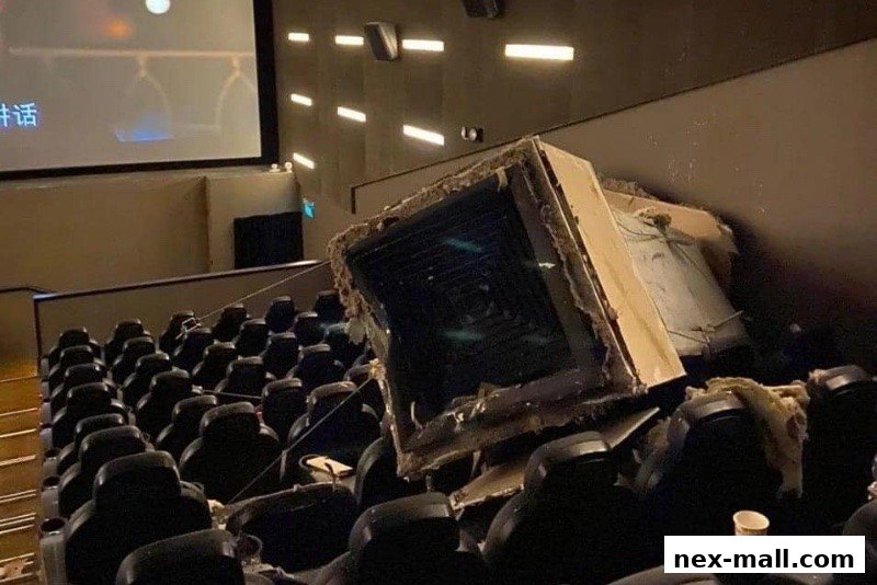 A damaged ceiling panel has fallen onto seats in a movie theater.
