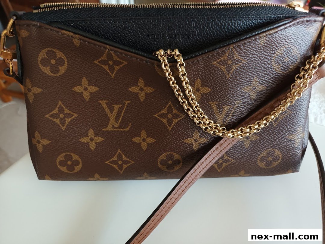 A close-up view of a designer handbag with the iconic monogram pattern and gold chain.