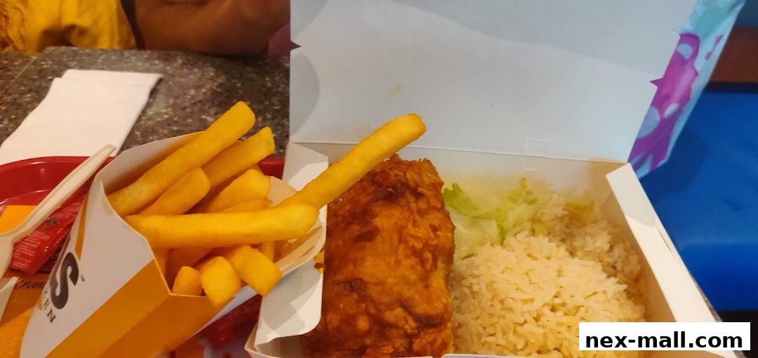 A close-up of a Texas Chicken meal with crispy fried chicken, rice, and fries.