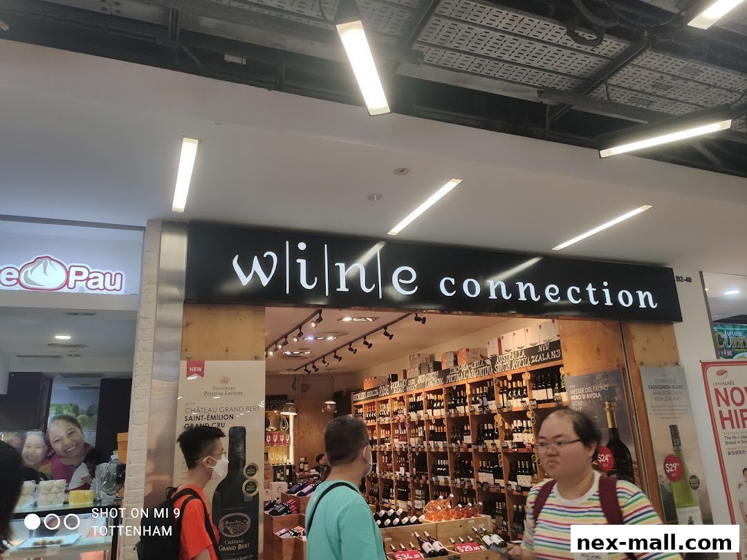 The exterior of a Wine Connection shop with a wide selection of wines displayed.
