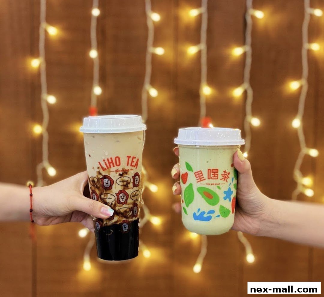 Two hands hold LiHO TEA drinks against a backdrop of fairy lights.