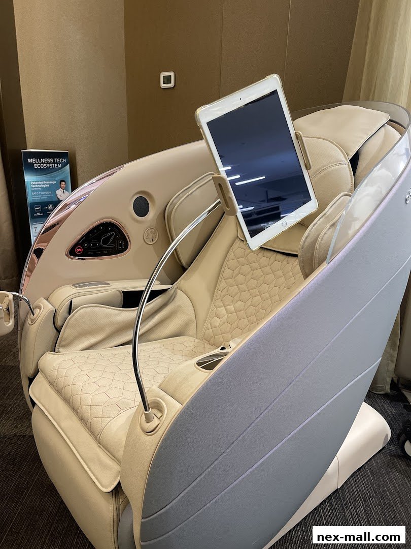 A luxurious massage chair with a tablet holder and a promotional poster in the background.