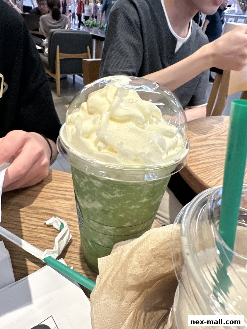 A close-up of a green Frappuccino topped with whipped cream at Starbucks.