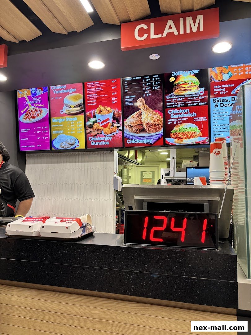 A Jollibee menu board displaying various chicken, burger, and side options with prices.